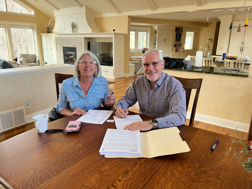 Fairway's Harlan Accola and his wife sign documents to close their own reverse mortgage in April 2022.